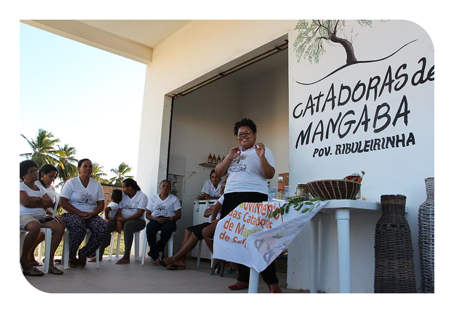 Cinco mulheres em roda, em pé, na mata. 