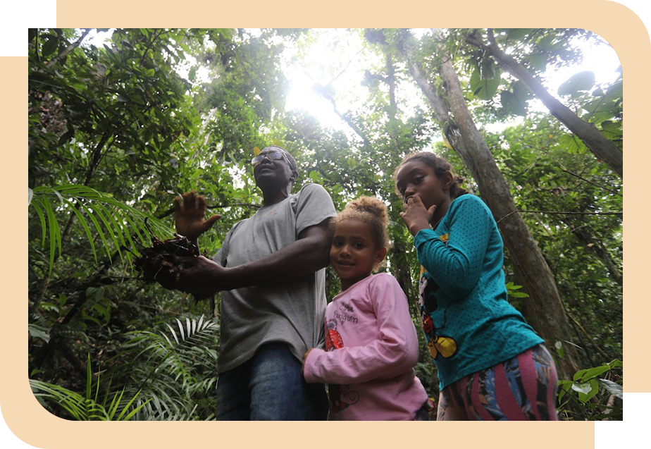 Mulher empurrando uma jangada na beira de um rio. 