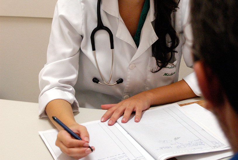 Médica fazendo anotações durante uma consulta.